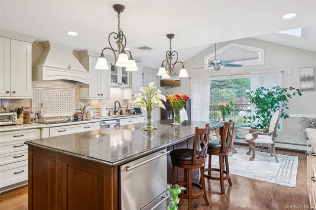 a kitchen with stainless steel appliances granite countertop a table and chairs in it