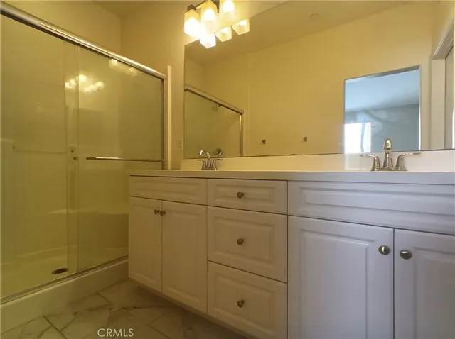 a bathroom with a double vanity sink mirror and shower