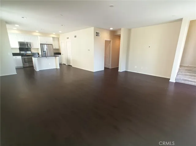 a view of a kitchen with kitchen island wooden floors wooden floor and appliances
