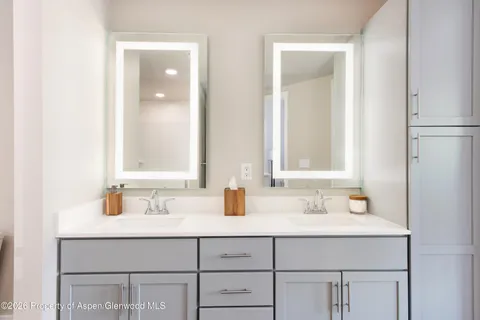 a bathroom with a granite countertop toilet a sink and shower