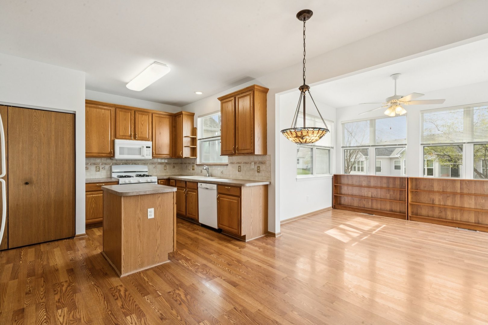 647 South Cadillac Circle Romeoville, IL 60446 - Photo 12 of 38 a kitchen with stainless steel appliances granite countertop a stove a sink dishwasher a refrigerator and a dining table with wooden floor