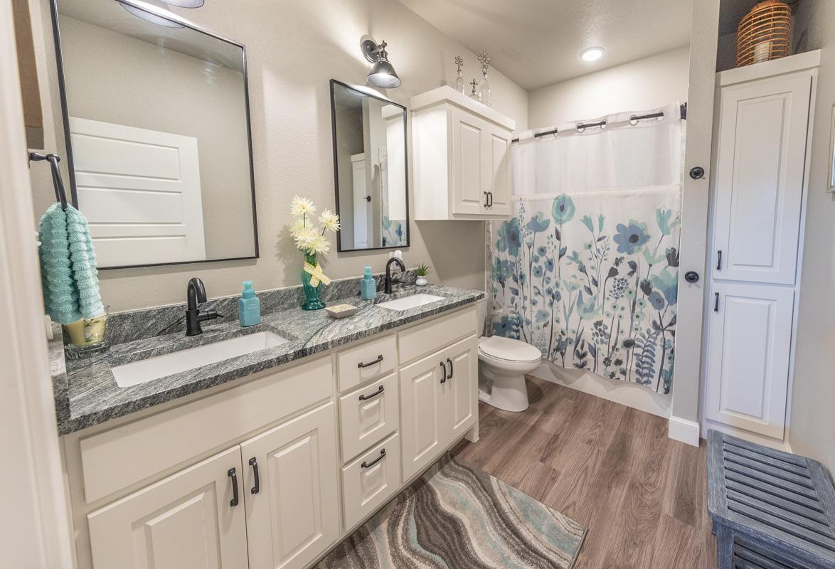 7002 103rd Street Lubbock, TX 79424 - Photo 15 of 28 a spacious bathroom with a granite countertop sink toilet and shower
