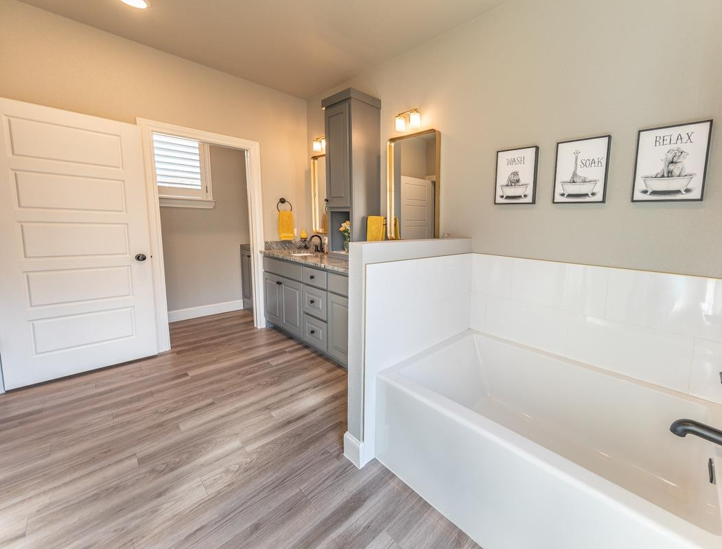 7002 103rd Street Lubbock, TX 79424 - Photo 23 of 28 a spacious bathroom with a tub sink and mirror