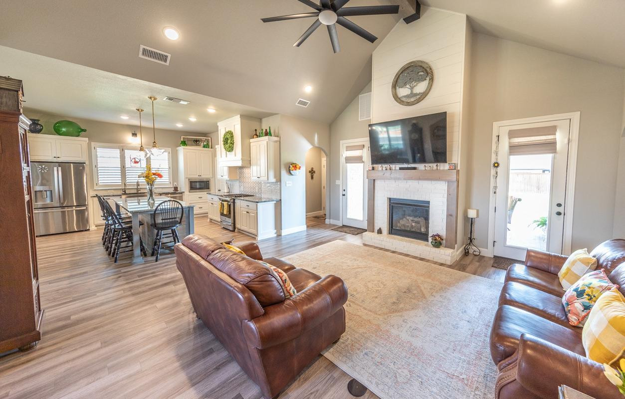 7002 103rd Street Lubbock, TX 79424 - Photo 4 of 28 a living room with furniture a clock and a fireplace