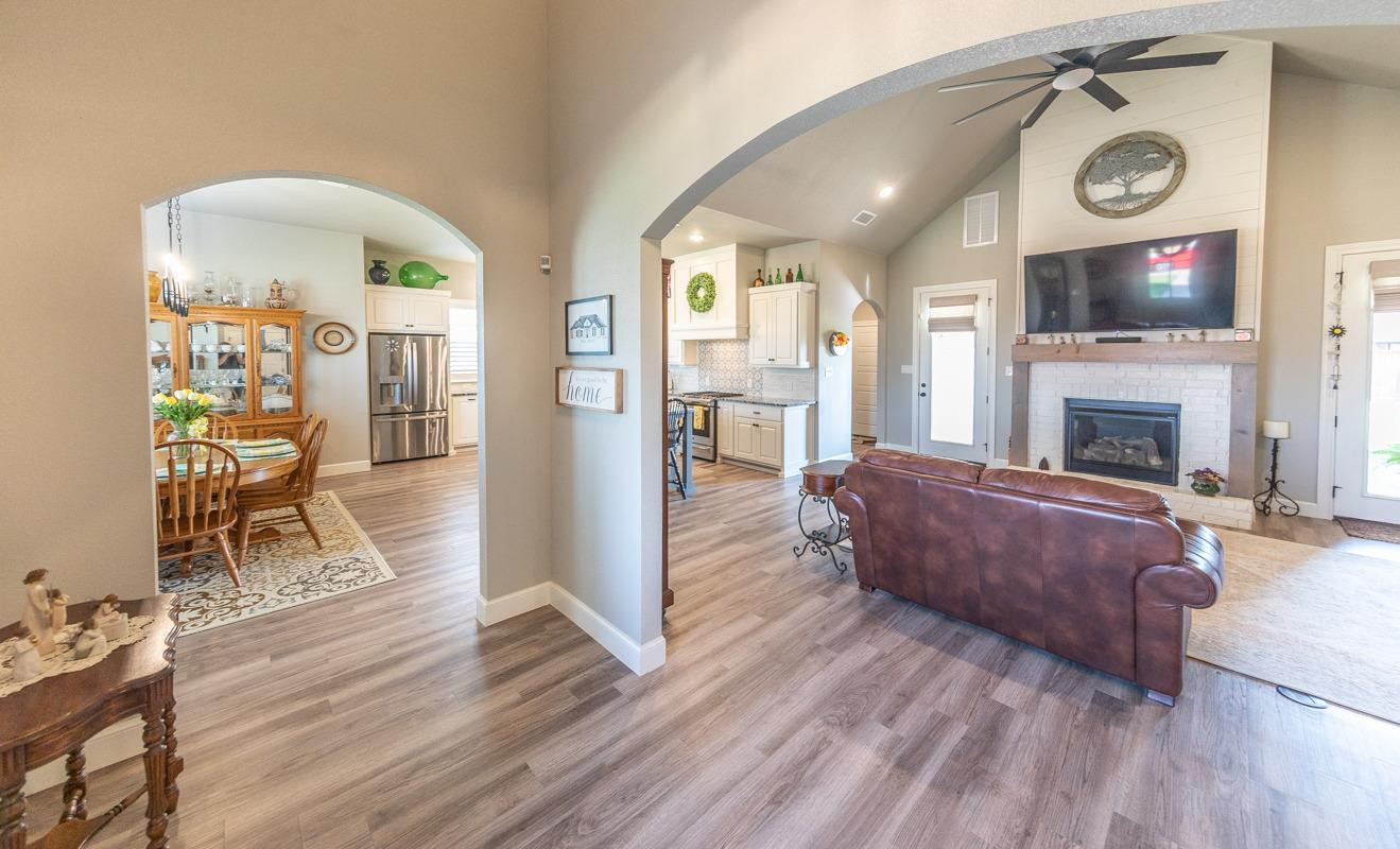 7002 103rd Street Lubbock, TX 79424 - Photo 6 of 28 a living room with furniture a flat screen tv and a fireplace