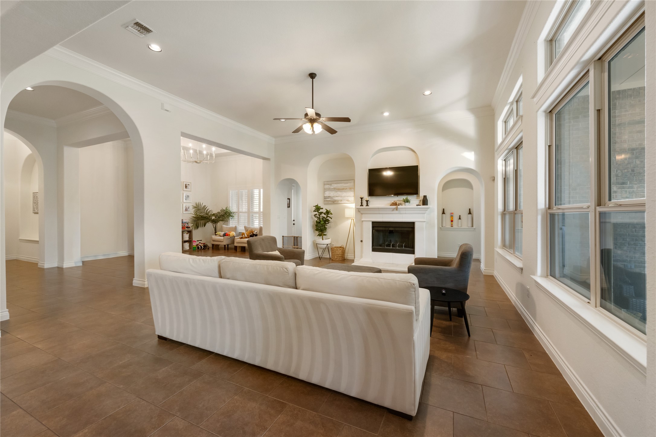 415 Bitterroot Lane Austin, TX 78737 - Photo 7 of 25 Architectural arches and plentiful windows illuminate this grand living area, complete with a cozy fireplace.
