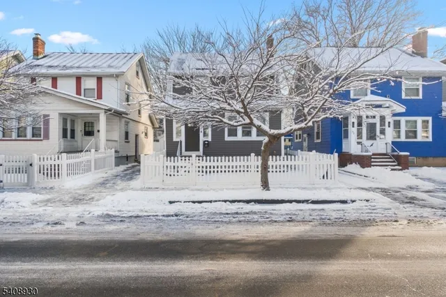 a view of a white house with a snow on the side of it
