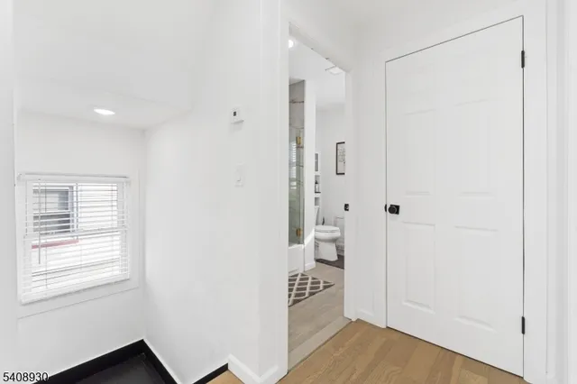 a view of an empty room with closet and a window