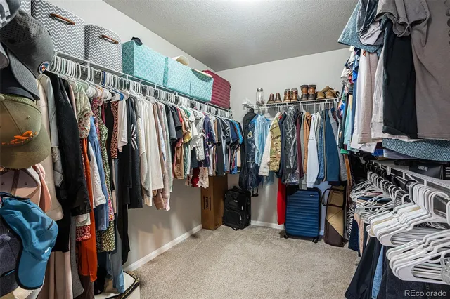 a view of walk in closet with clothes