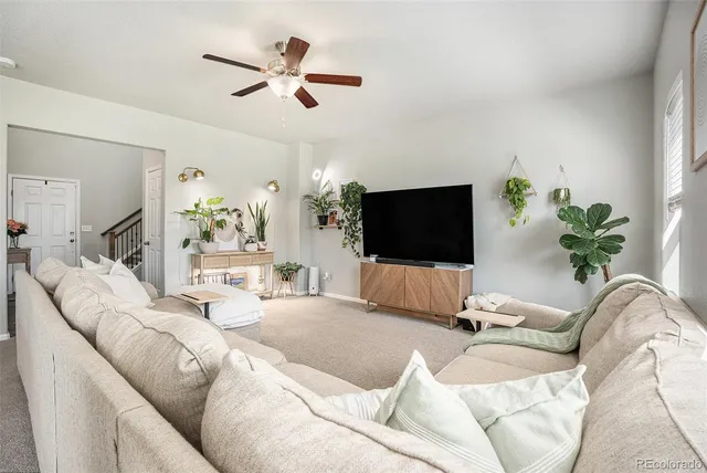 a living room with furniture kitchen view and a chandelier