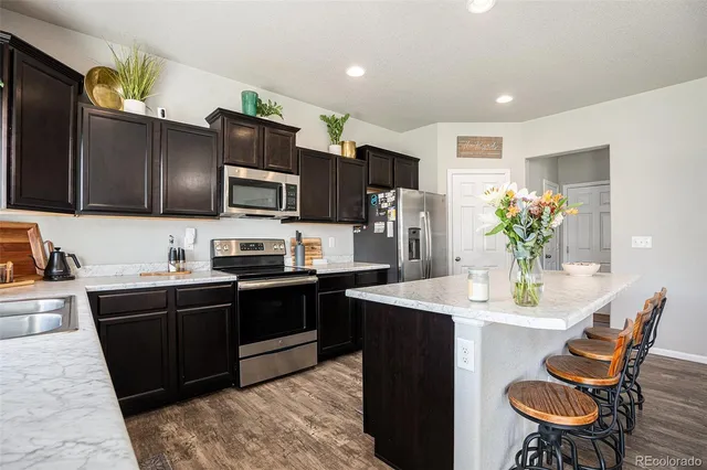 a kitchen with stainless steel appliances granite countertop a refrigerator and a sink