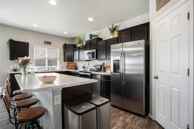 a kitchen with a refrigerator and a stove top oven