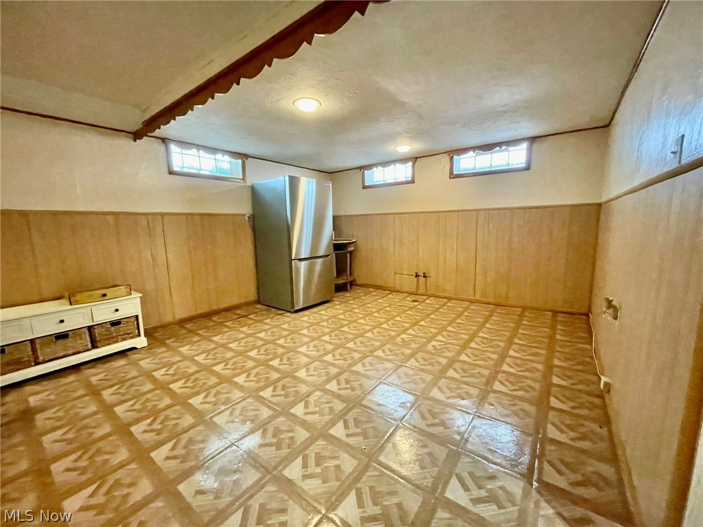 28634 Forest Road Willowick, OH 44095 - Photo 37 of 39 Spacious room featuring patterned flooring, wood paneling, light-colored walls, and multiple windows