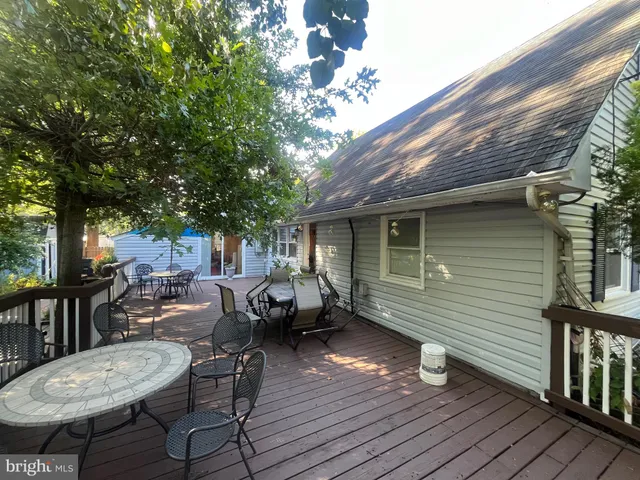 a backyard of a house with wooden floor table and chairs