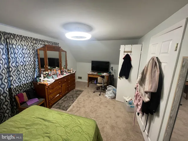 a bed room with a bed a television and a couch