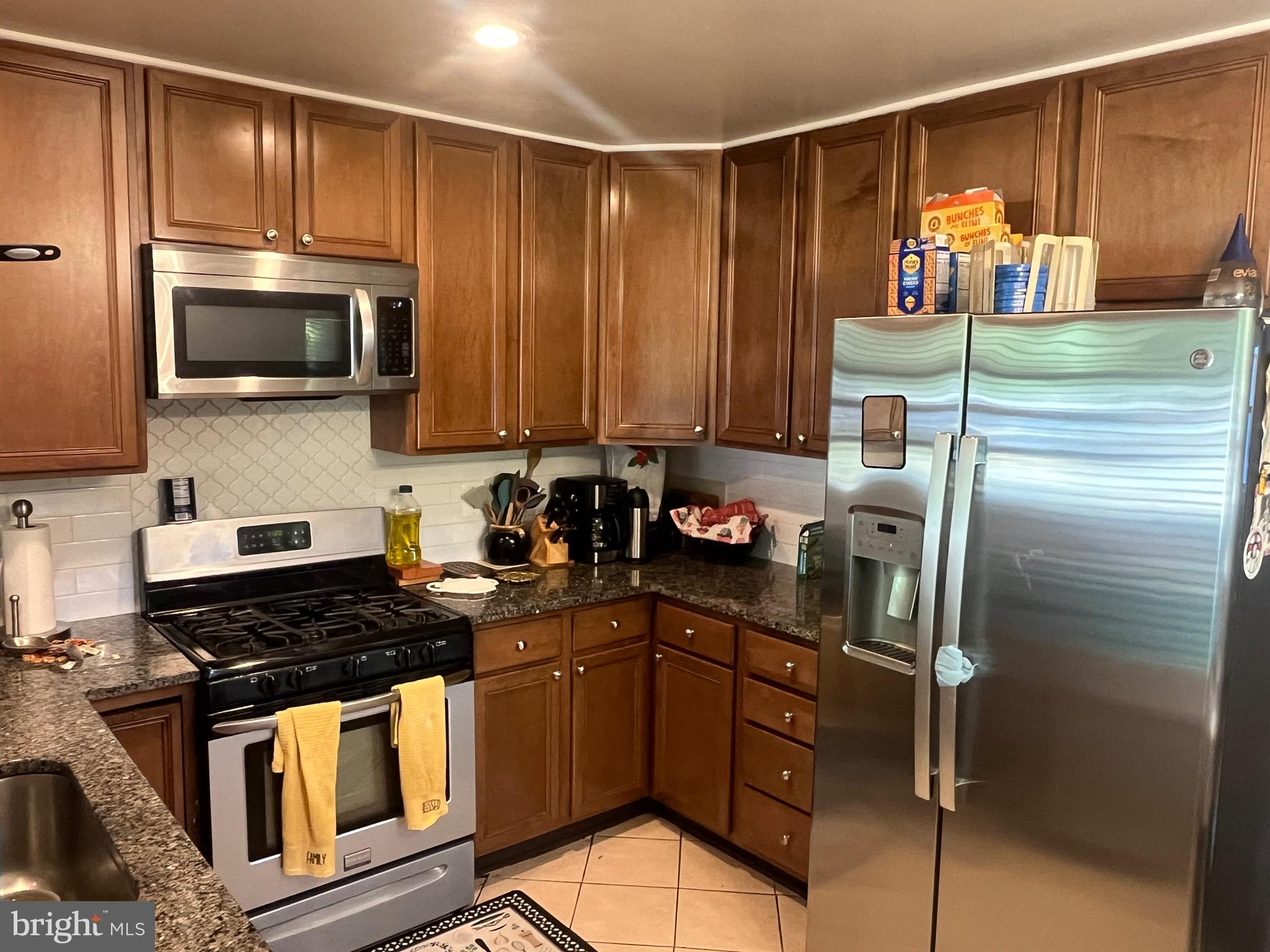 8139 Keeler Street Alexandria, VA 22309 - Photo 3 of 49 a kitchen with a refrigerator and a stove top oven