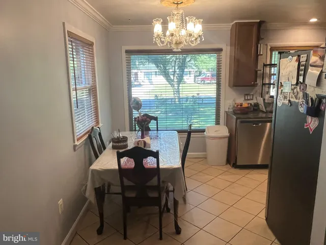 a view of a dining room with furniture a chandelier and window