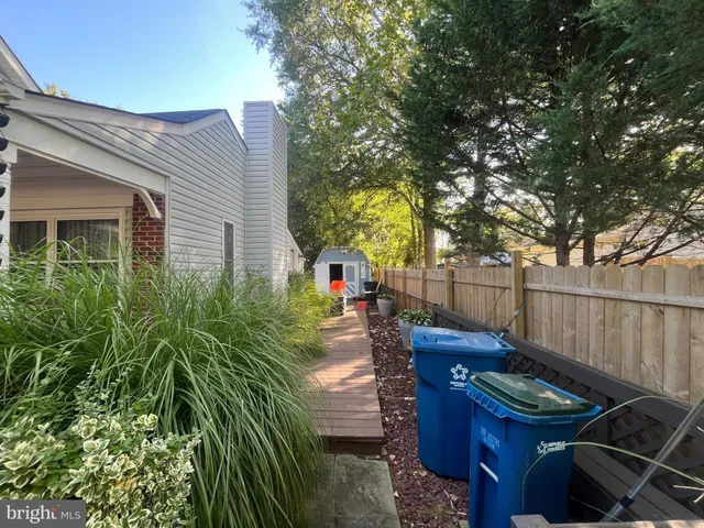 a view of a patio with table and chairs with wooden fence and plants