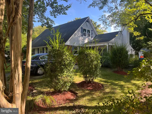 a view of a house with a small yard plants and large tree