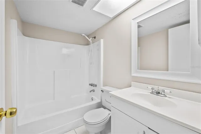 a bathroom with a granite countertop sink a toilet and shower