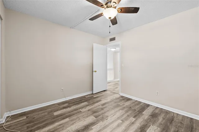 en empty room with ceiling fan and window
