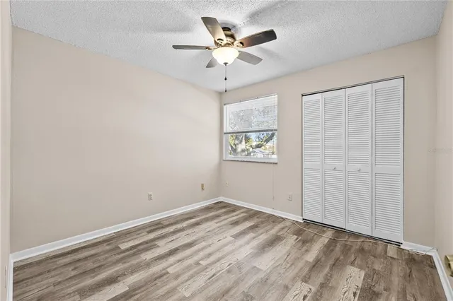 an empty room with a ceiling fan and a window