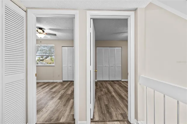 a view of a hallway with wooden floor and a livingroom