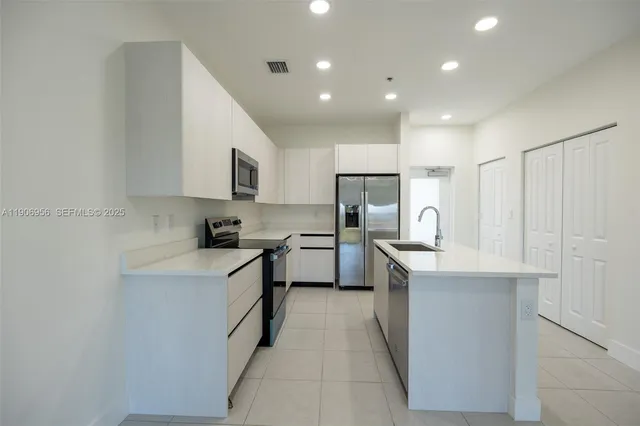 a kitchen with white cabinets and stainless steel appliances