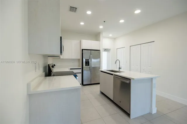 a kitchen with stainless steel appliances a sink stove and refrigerator