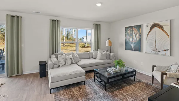 a living room with furniture a large window and a potted plant