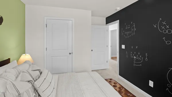 a bedroom with a bed and a lamp on desk