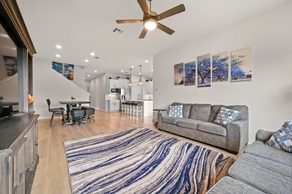 a bedroom with a large bed and a chandelier fan