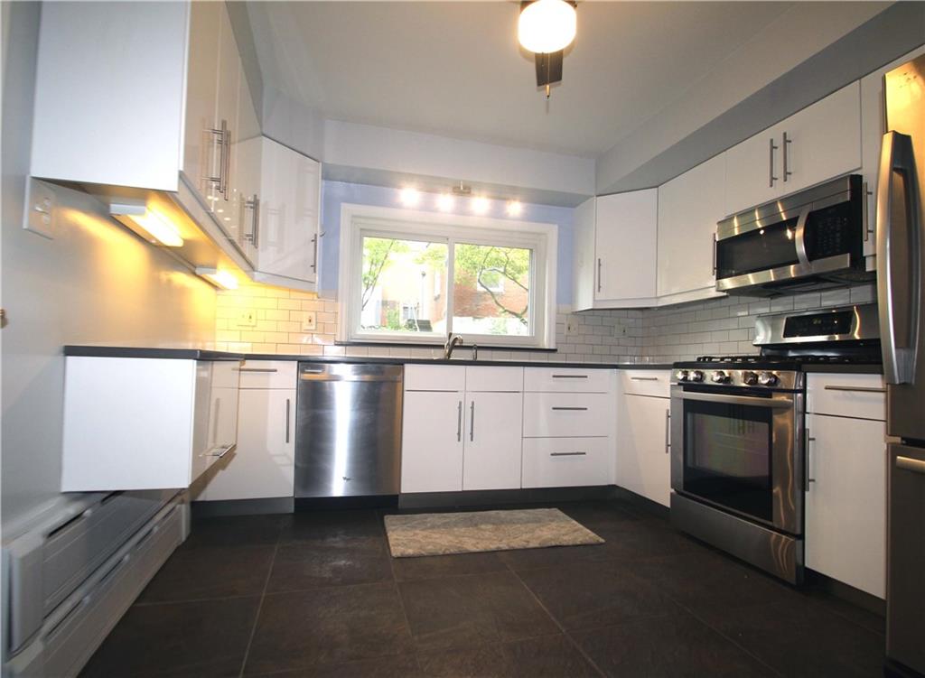 229 Edmond Street Pittsburgh, PA 15224 - Photo 11 of 22 a kitchen with stainless steel appliances granite countertop a sink a stove and a microwave