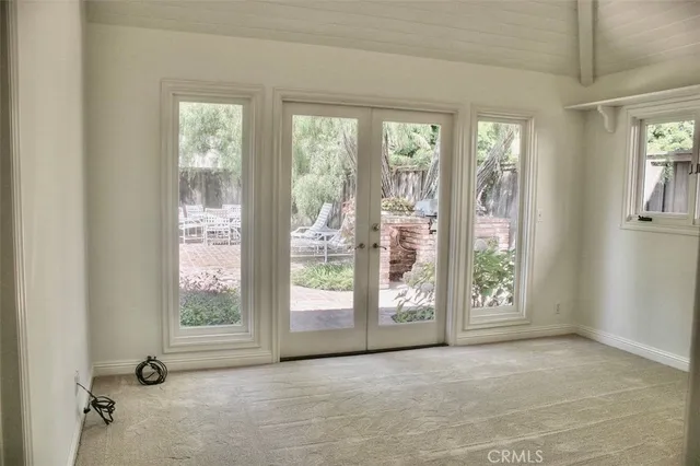 a view of an empty room with a window and a fireplace