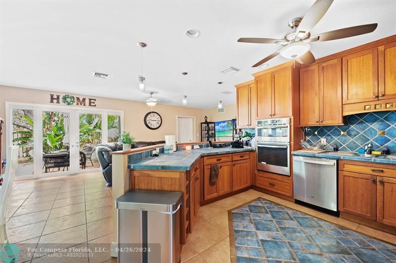 a kitchen with stainless steel appliances granite countertop a stove top oven a sink dishwasher and cabinets with wooden floor
