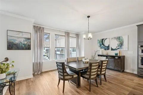 a kitchen with stainless steel appliances a dining table chairs refrigerator and sink