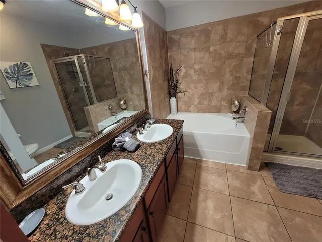 a bathroom with a sink a toilet a mirror and shower