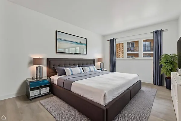 a spacious bedroom with a bed and a potted plant
