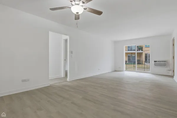 an empty room with chandelier fan