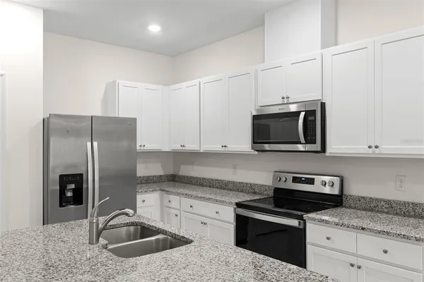 a large kitchen with stainless steel appliances lots of counter space and a sink