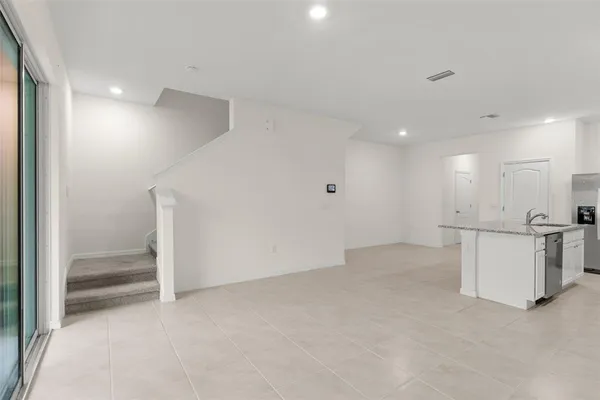 a view of kitchen with kitchen island a sink stainless steel appliances and cabinets