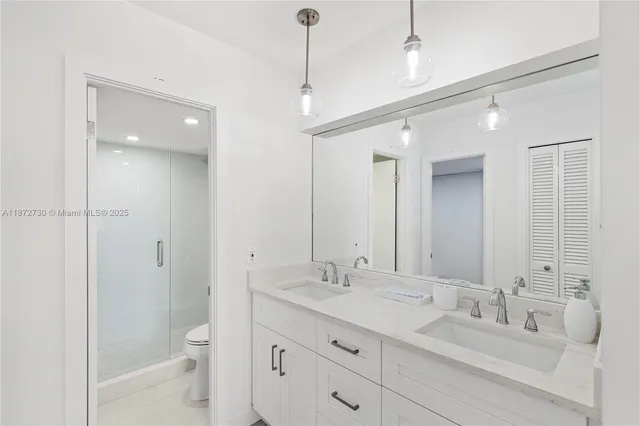 a spacious bathroom with a granite countertop sink a toilet and a shower