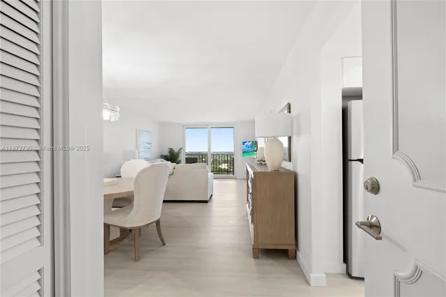 a living room with furniture a lamp and a view of kitchen