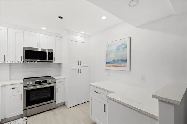 a kitchen with stainless steel appliances a stove microwave and sink