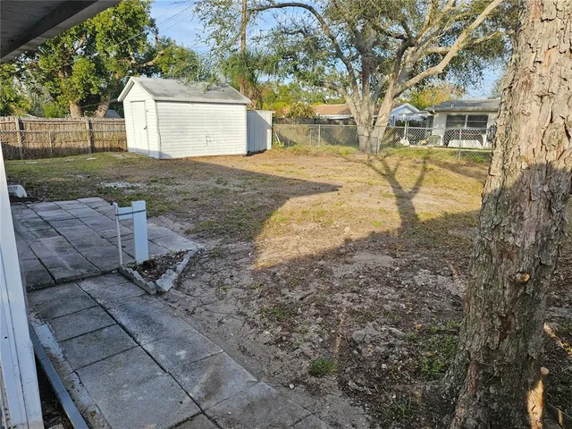 a view of a yard with plants and trees