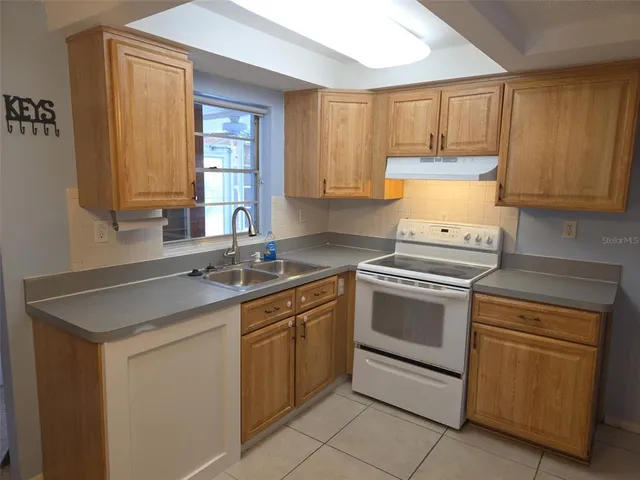 a kitchen with a sink stove and cabinets