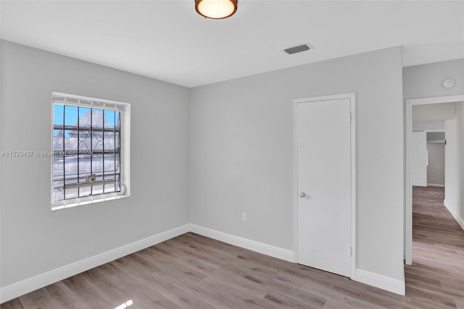 1101 Northwest 147th Street Miami, FL 33168 - Photo 19 of 45 wooden floor in an empty room with a window