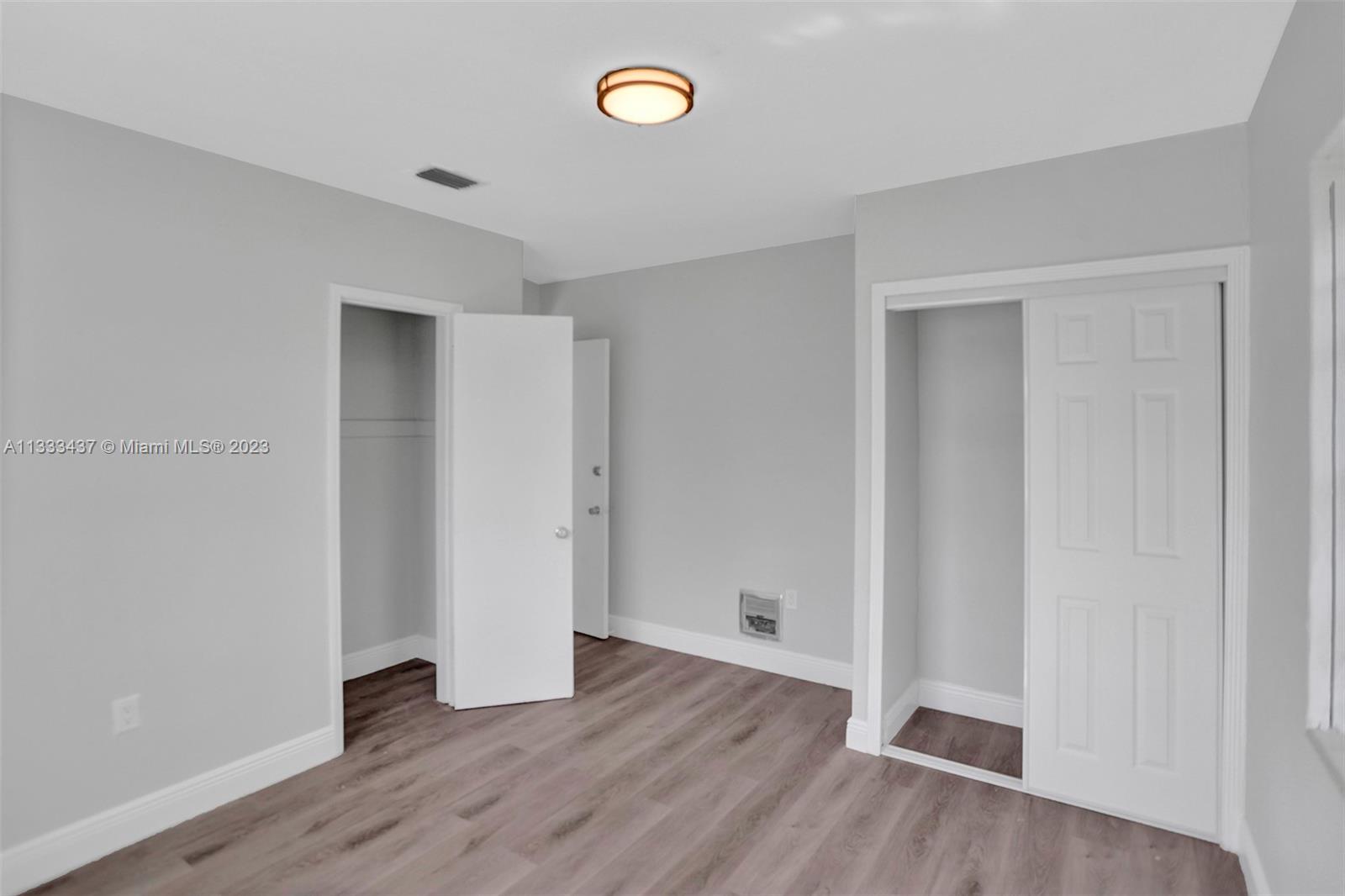 1101 Northwest 147th Street Miami, FL 33168 - Photo 20 of 45 an empty room with wooden floor and a window