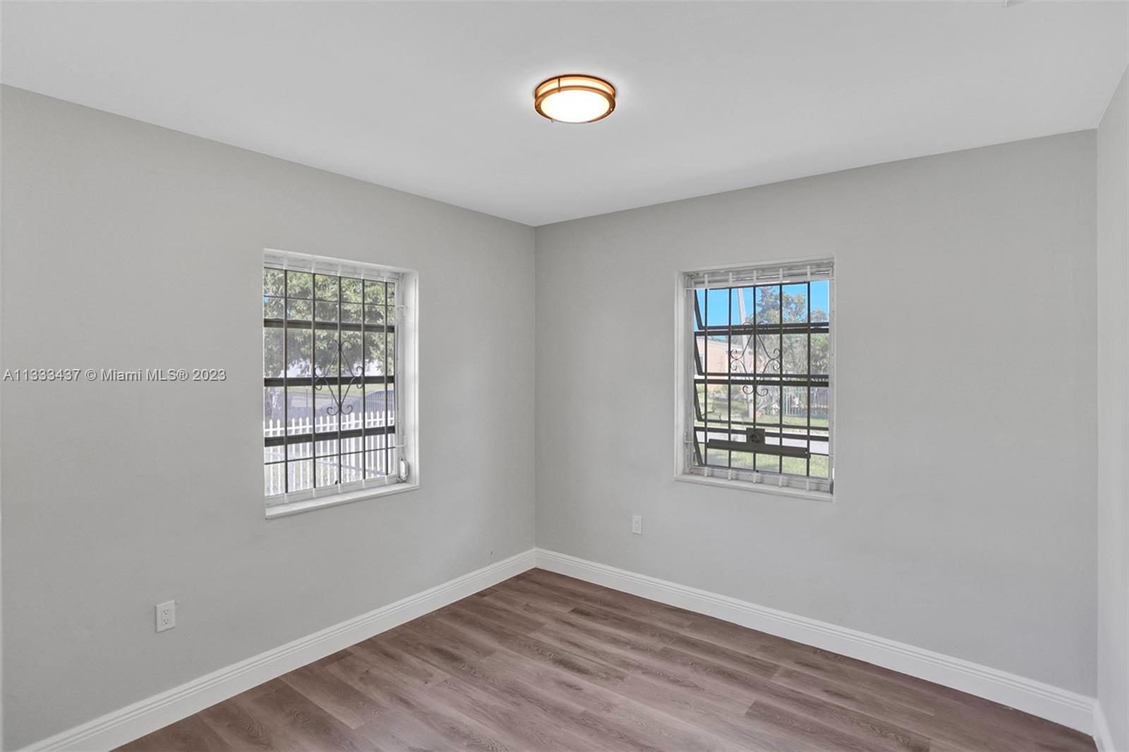 1101 Northwest 147th Street Miami, FL 33168 - Photo 22 of 45 a view of an empty room with a window and wooden floor