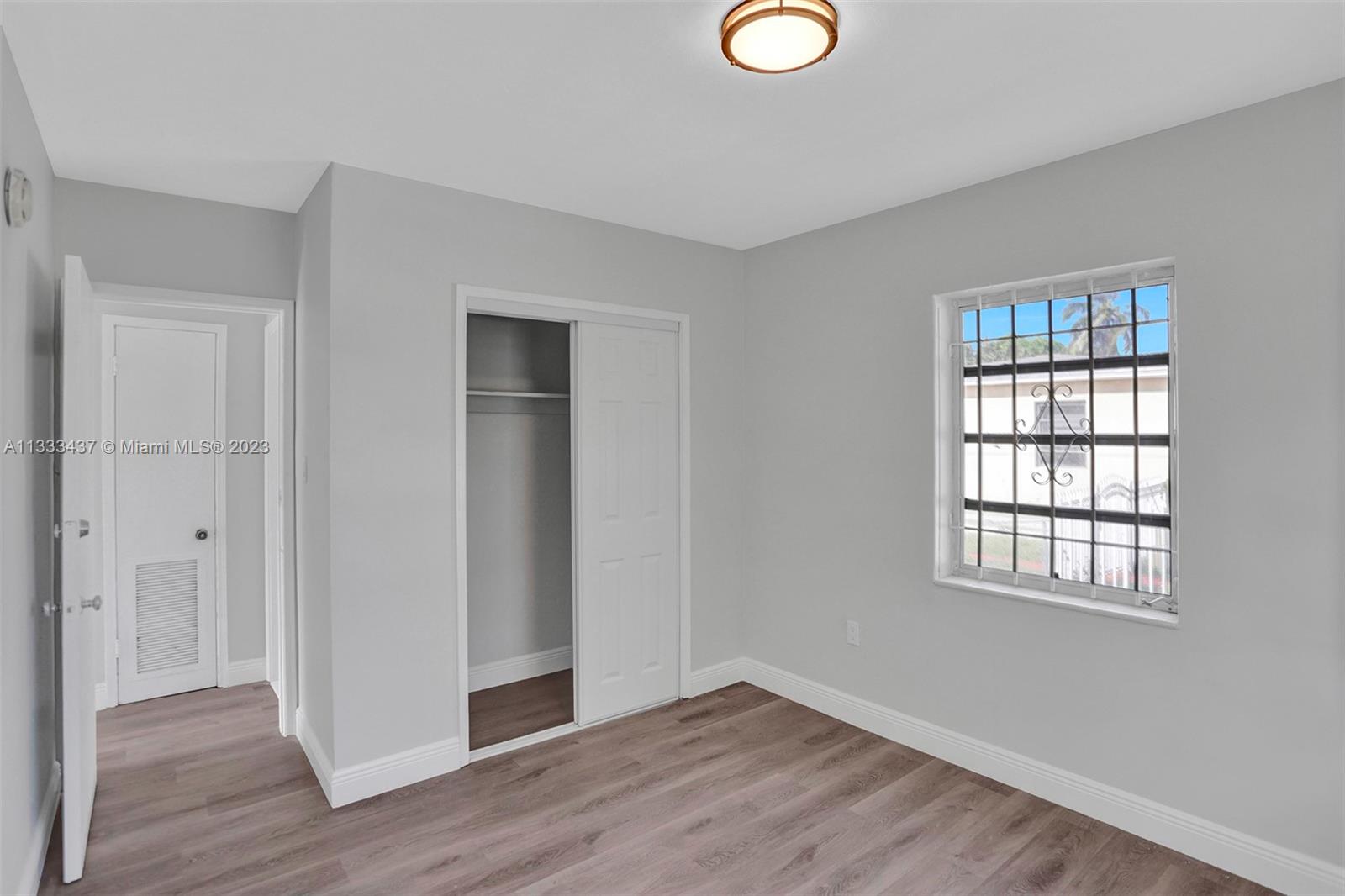 1101 Northwest 147th Street Miami, FL 33168 - Photo 23 of 45 a view of an empty room with wooden floor and a window